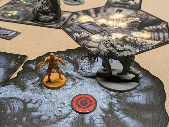 A scenario in play, with the Great Old One looming over the board, monster minis, and player areas.