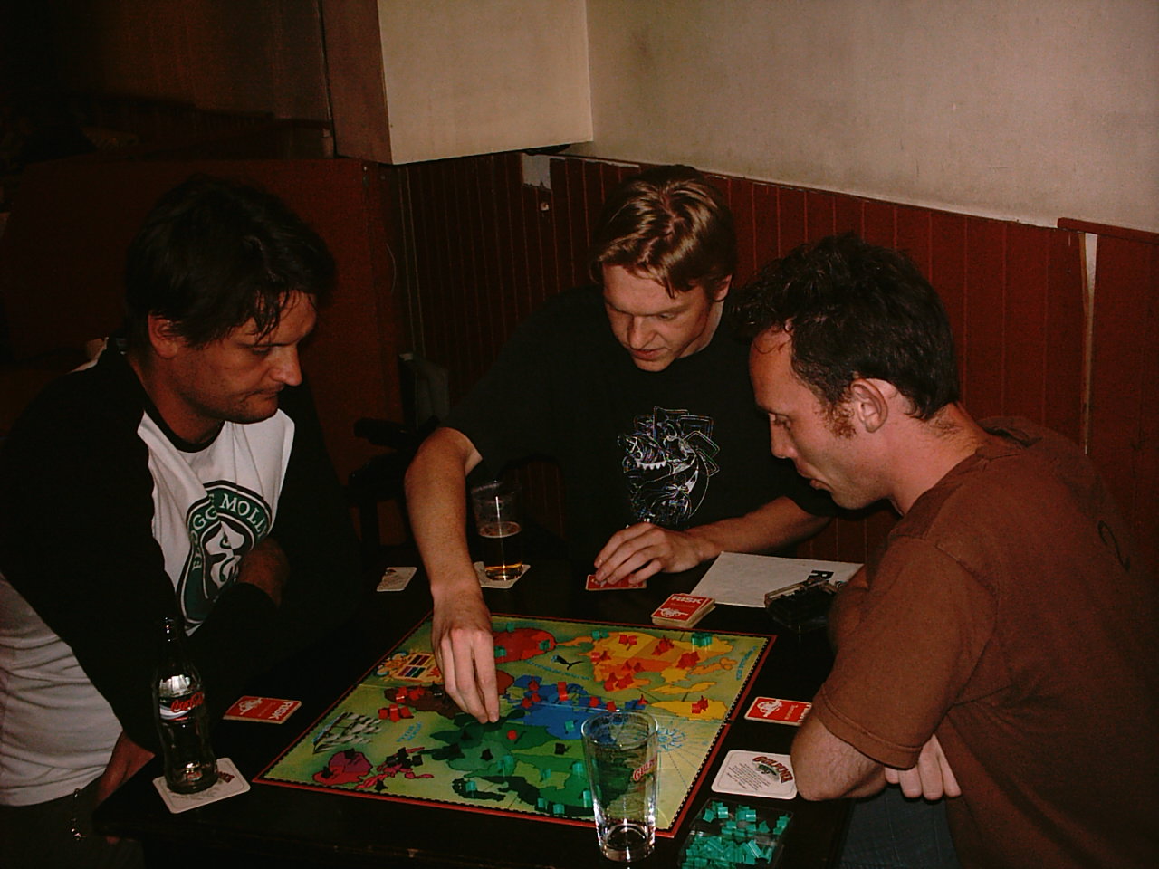 Friends gathered around a board game in mid-play.